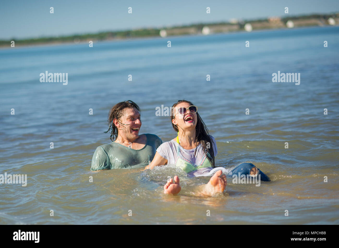 Young couple bathing in the sea. Guy and girl are merrily floundering