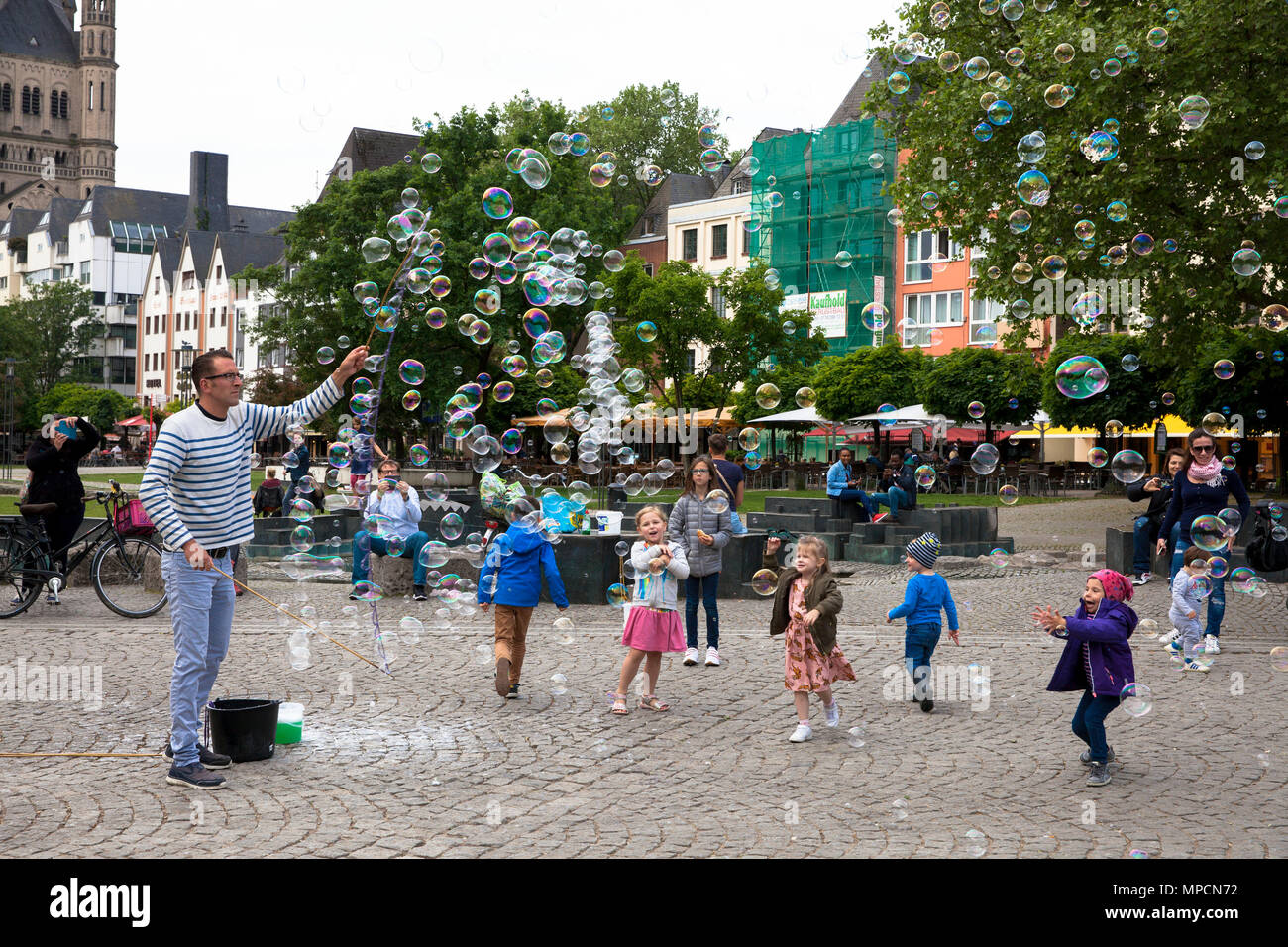 Europe, Germany, Cologne, man makes soap bubbles at the Rhine garden in the old part of the town.  Europa, Deutschland, Koeln, Mann macht Seifenblasen Stock Photo