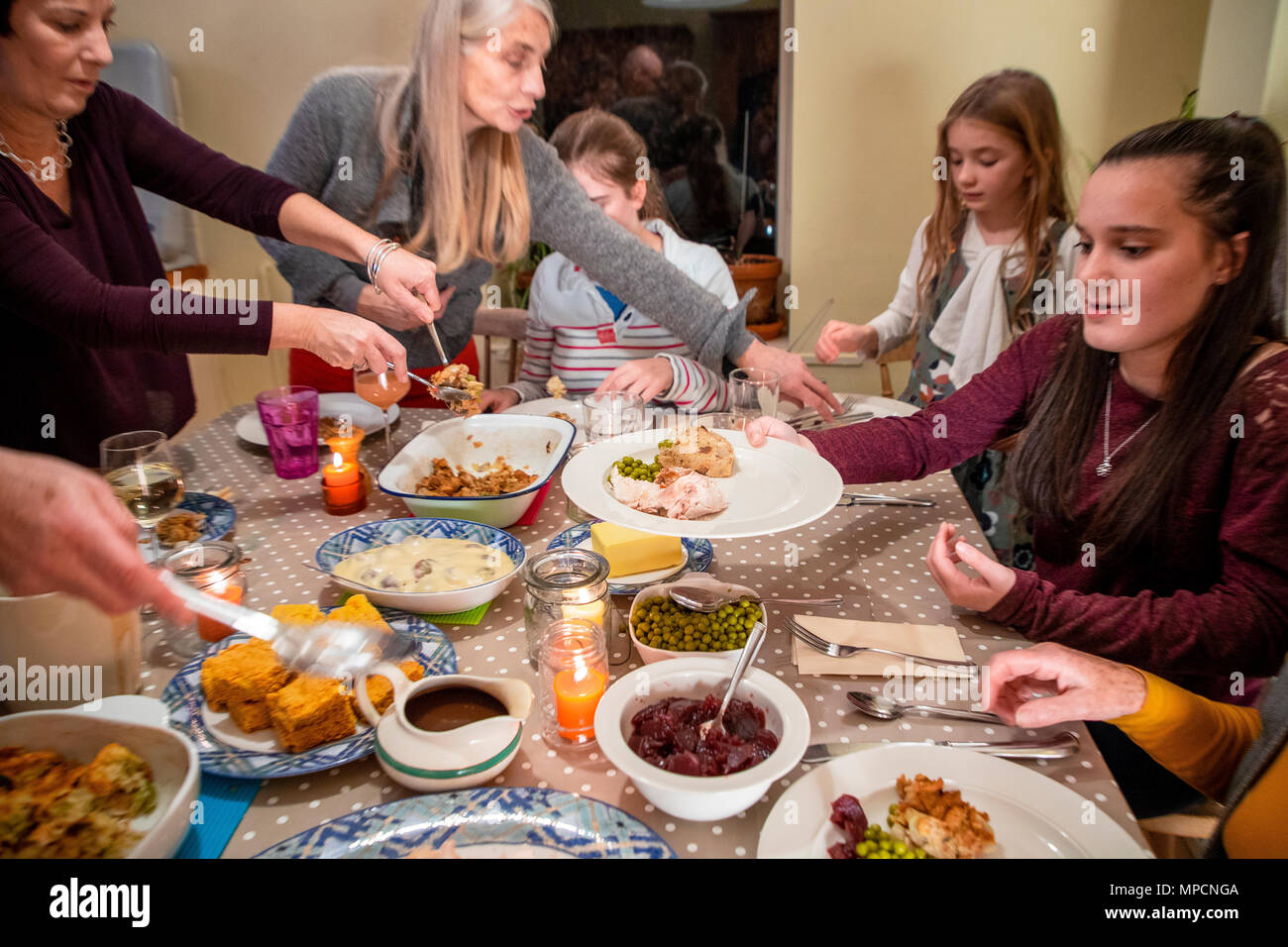 A family help themselves to a meal at Thanksgiving. Stock Photo