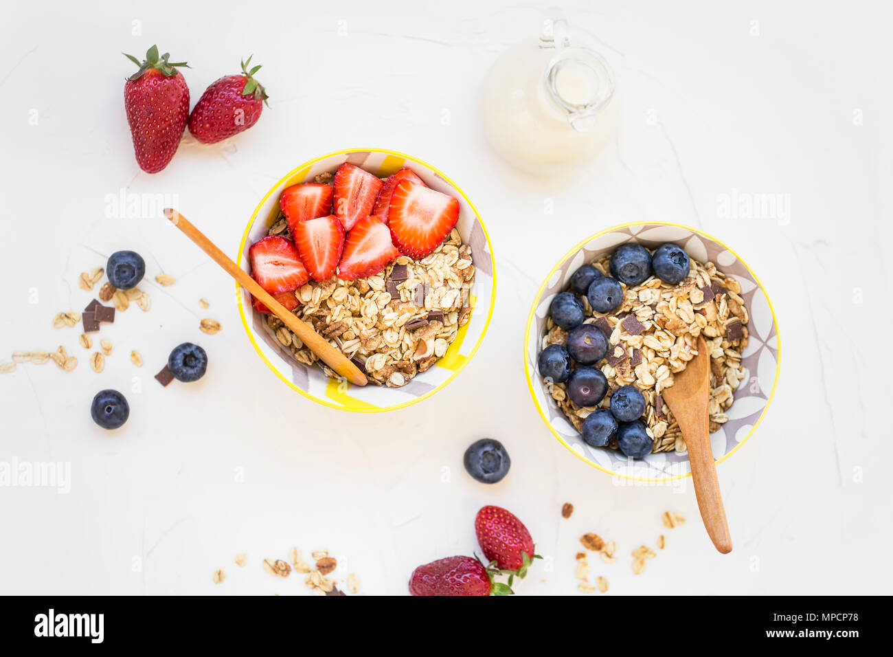 Muesli bowls with strawberries, blueberries fruits and milk , flatlay of healthy breakfast bowls Stock Photo