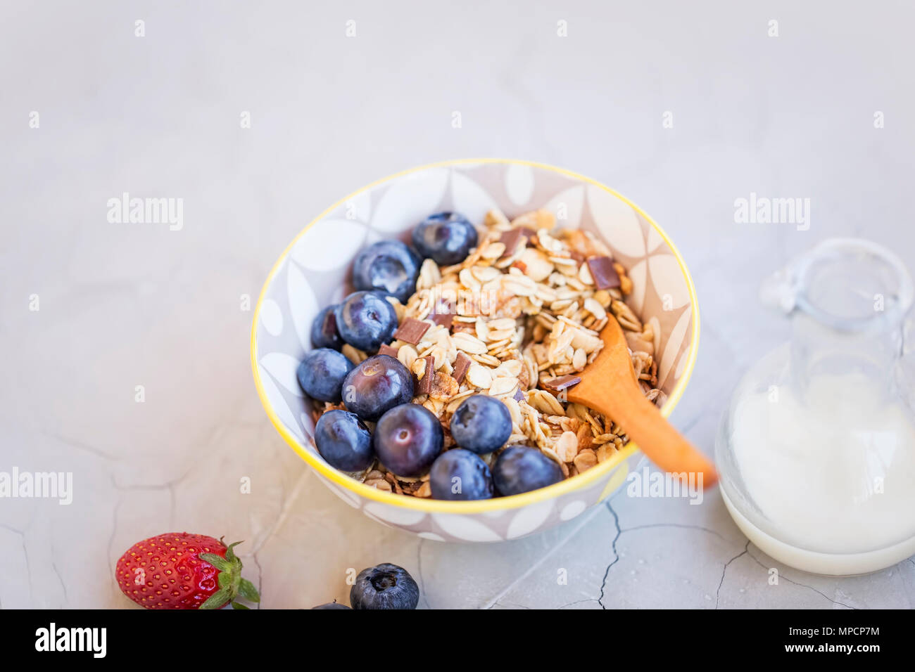 Bowl of muesli with blueberries fruits, healthy breakfast with oatmeal, milk and fruits Stock Photo