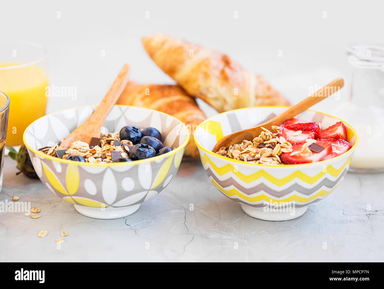 Muesli bowls with strawberries, blueberries fruits and milk ,healthy breakfast bowls Stock Photo