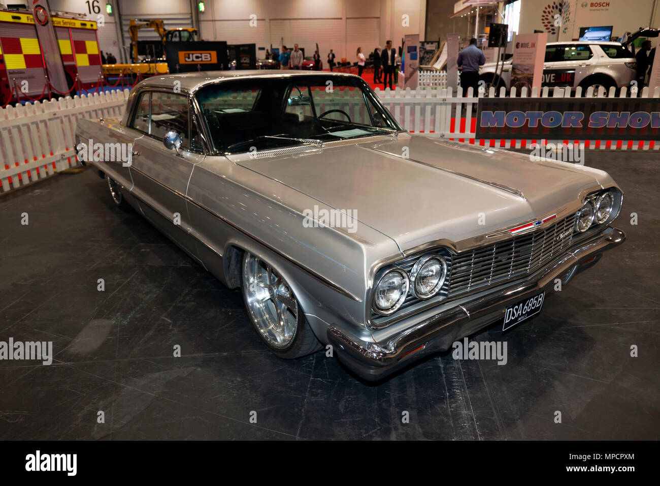 Three-quarter front view of a 1964 Silver, Chevrolet Impala, on display at the 2018 London Motor Show Stock Photo