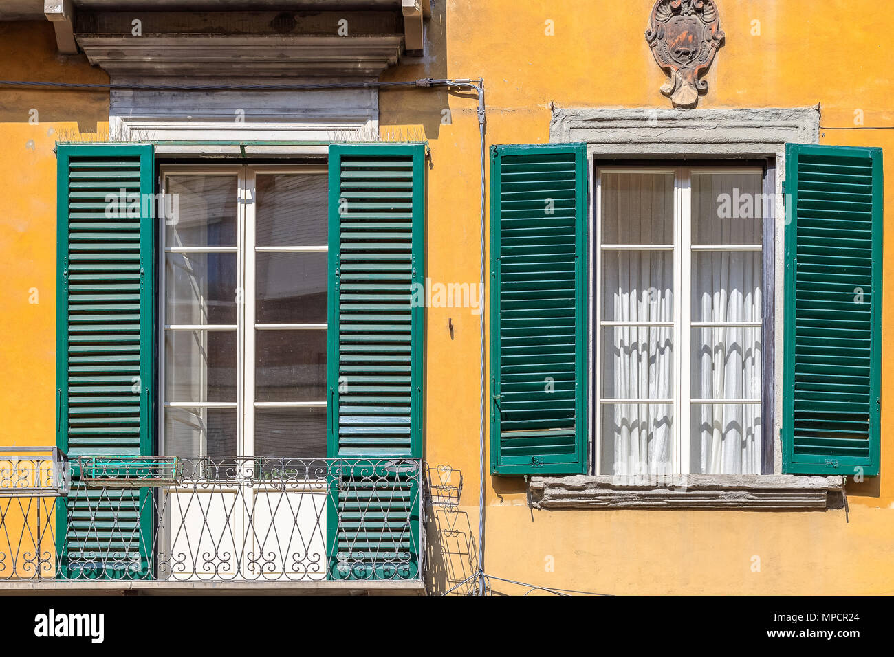 Exterior of traditional Italian buildings with green shutters in Pisa, Italy Stock Photo
