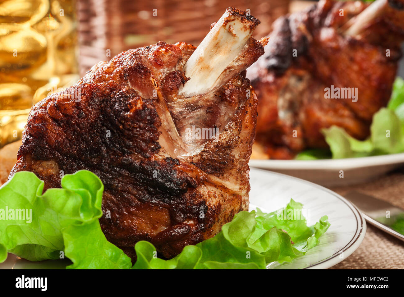 Roasted turkey knuckle with fried potato slices on a plate Stock Photo