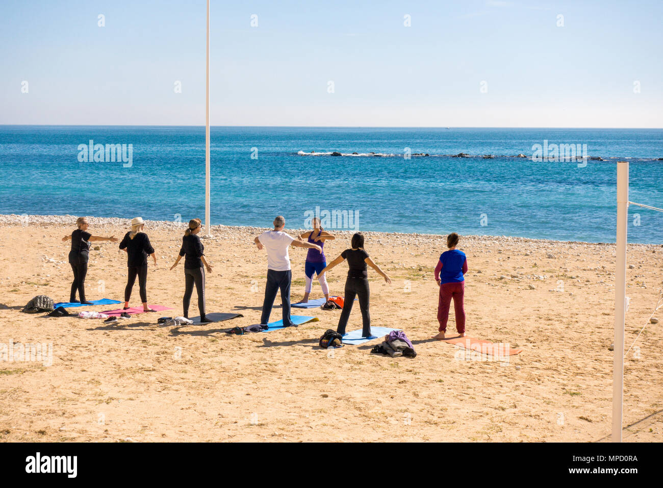 Active people doing exercises on the beach in Altea, Spain. Stock Photo
