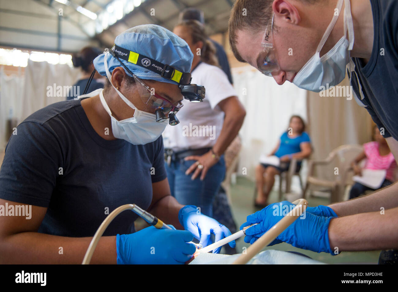 170203-N-YL073-193 (Feb. 3, 2017) PUERTO BARRIOS - Lt. Charlie Cage, a native of Jacksonville, Fla., attached to Naval Hospital Jacksonville (left), and Hospitalman Lucas Guinon, a native of Valeo, Calif., perform dental work on a host nation patient at the Continuing Promise 2017 (CP-17) medical site in Puerto Barrios, Guatemala. CP-17 is a U.S. Southern Command-sponsored and U.S. Naval Forces Southern Command/U.S. 4th Fleet-conducted deployment to conduct civil-military operations including humanitarian assistance, training engagements, and medical, dental, and veterinary support in an effor Stock Photo