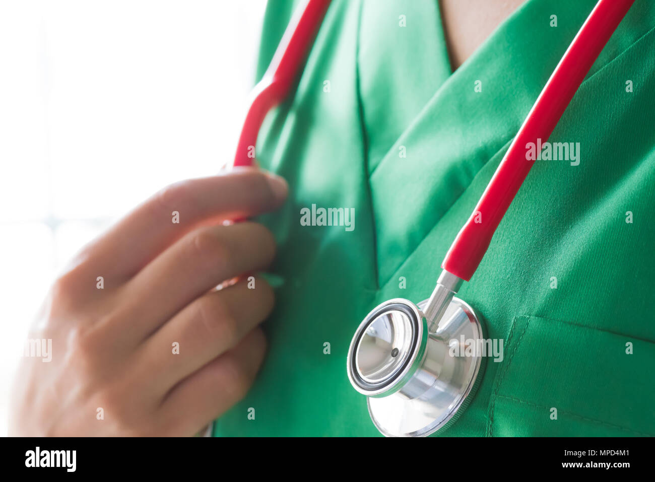 Doctor wearing green scrub suit with stethoscope isolated on white
