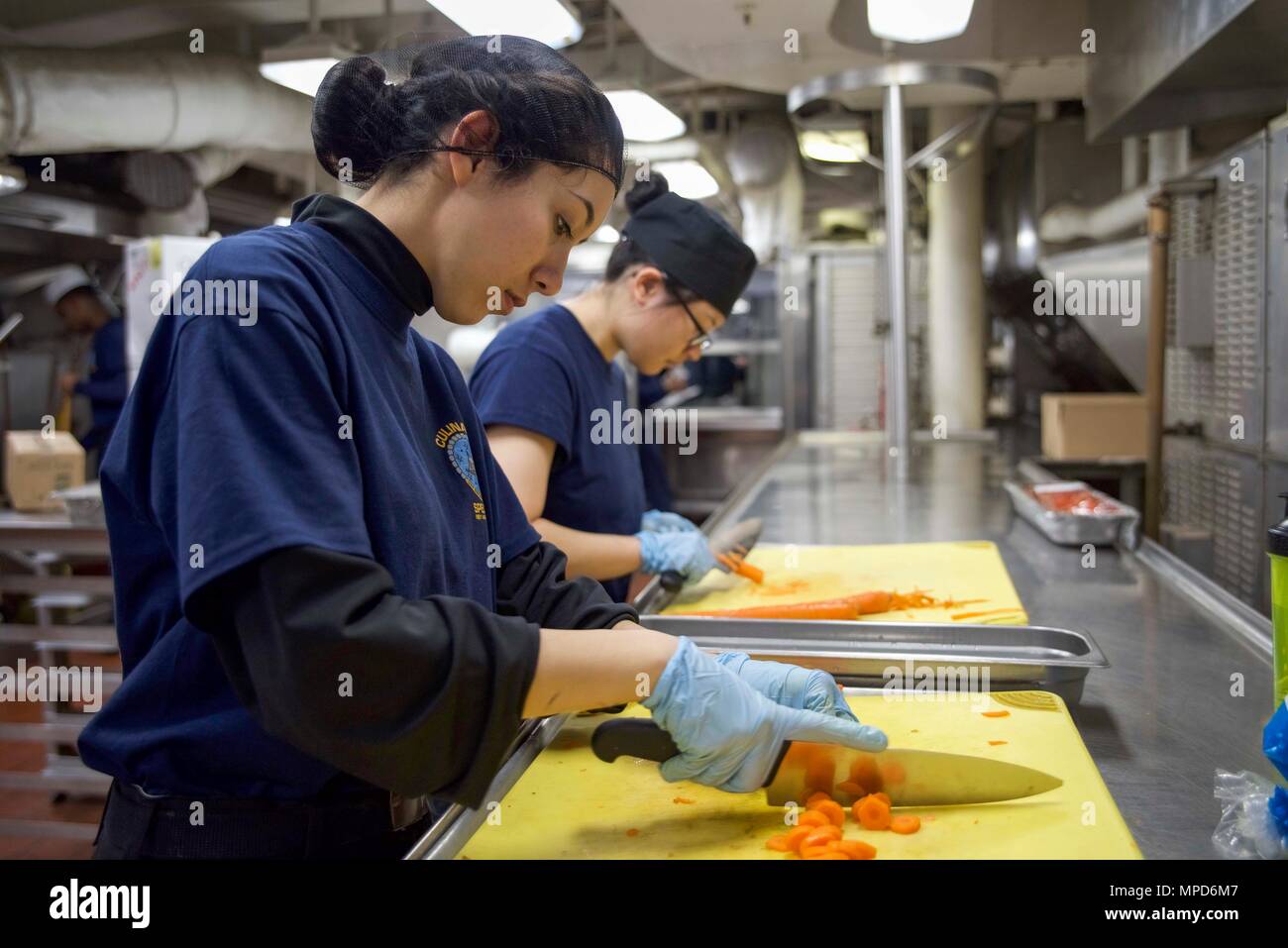 170204-N-IE397-014  NORFOLK, Va. (Feb. 4, 2017) Culinary Specialist Seaman Yecy Marty, left, and Culinary Specialist Seaman Hien Nguyen, from Charlotte, N.C., prepare carrots for the salad bar in the forward galley of the aircraft carrier USS Dwight D. Eisenhower (CVN 69) (Ike). Ike is currently conducting aircraft carrier qualifications during the Sustainment Phase of the Optimized Fleet Response Plan (OFRP). (U.S. Navy photo by Mass Communication Specialist 3rd Class Christopher A. Michaels) Stock Photo