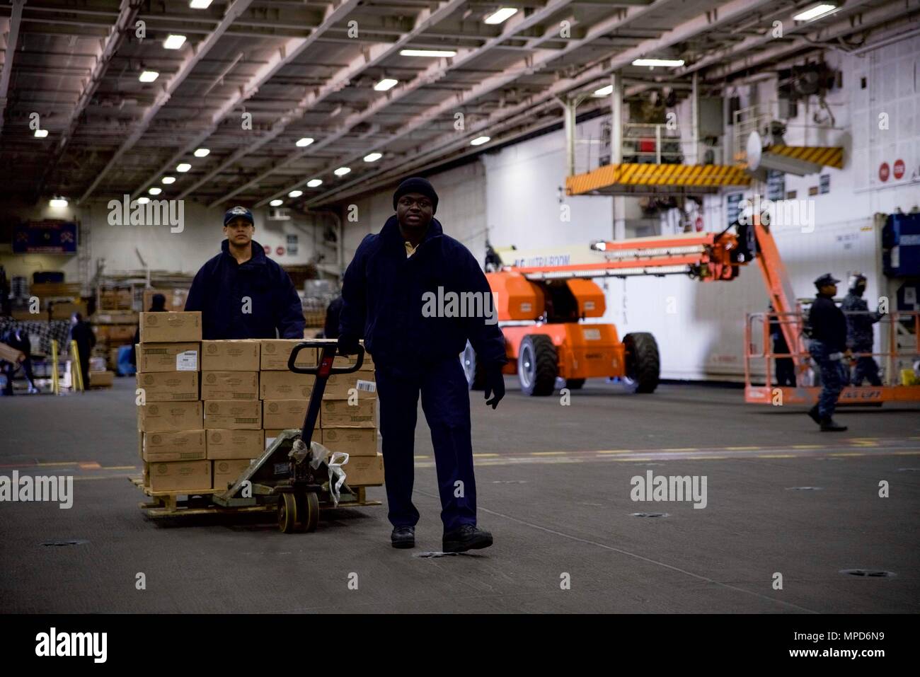 170204-N-IE397-002  NORFOLK, Va. (Feb. 4, 2017) Culinary Specialist Seaman Sodou Amoussi, from Gainesville, Ga., right, and Culinary Specialist Seaman Jonathan Mcleod-Peters transport supplies across the hangar bay of the aircraft carrier USS Dwight D. Eisenhower (CVN 69) (Ike). Ike is currently conducting aircraft carrier qualifications during the Sustainment Phase of the Optimized Fleet Response Plan (OFRP). (U.S. Navy photo by Mass Communication Specialist 3rd Class Christopher A. Michaels) Stock Photo