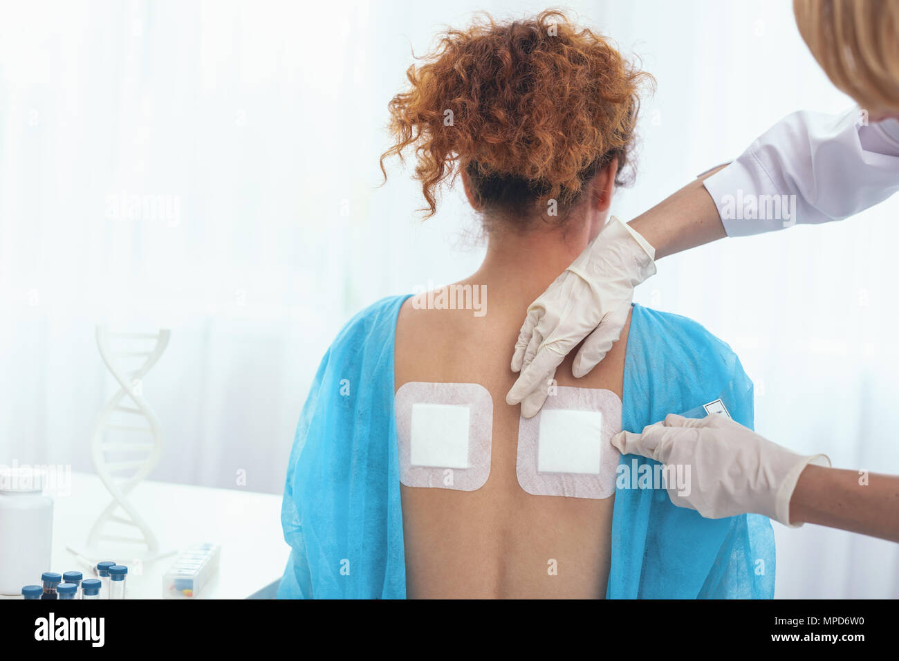 Young girl being offered heat plasters for pain relief Stock Photo