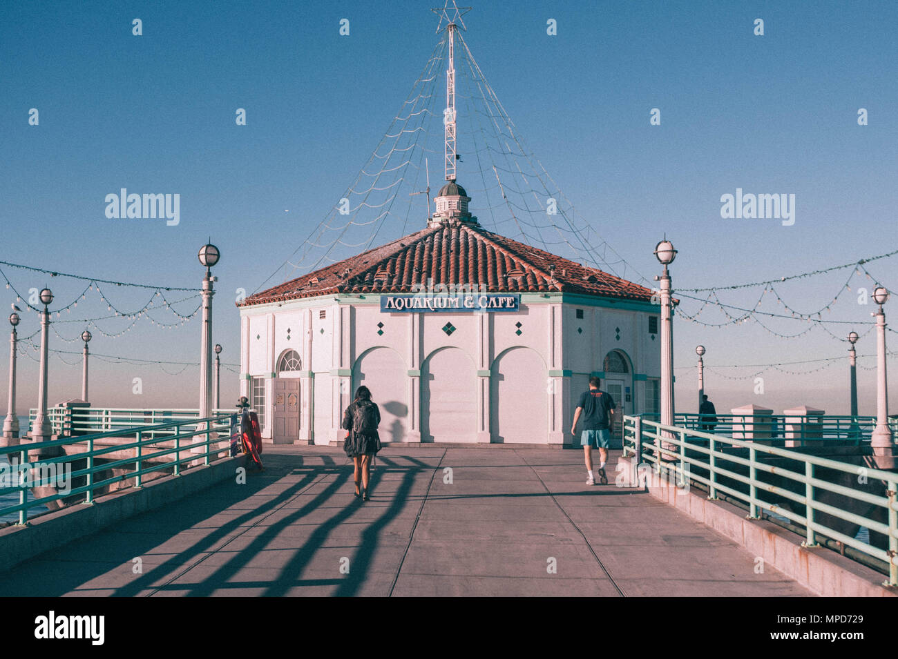 A man in a blue shirt and white pants photo – Free Manhattan beach