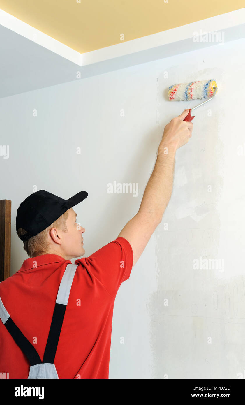 Worker adhesive wallpapers. He put glue on the wall using a roller