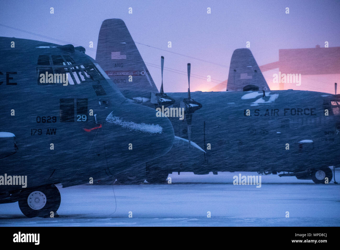 179th Airlift Wing Maintenance members prep the fleet of C-130H Hercules as a blanket of snow descends on them Feb. 9, 2017, at the 179th Airlift Wing, Mansfield, Ohio.  The 179th Airlift Wing is always on mission to be the first choice to respond to community, state and federal missions with a trusted team of highly qualified Airmen. (U.S. Air National Guard photo by 1st Lt. Paul Stennett/Released) Stock Photo