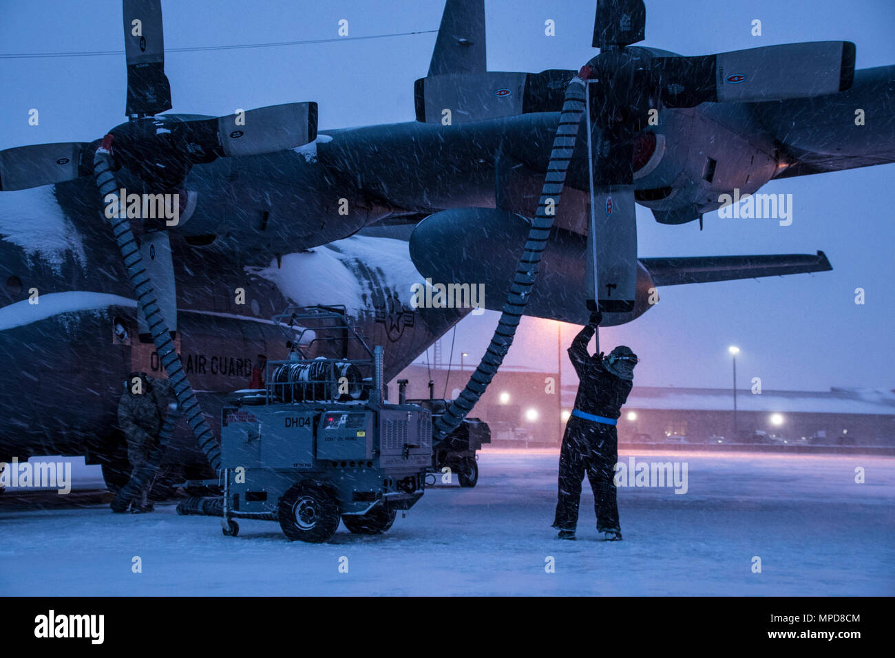 179th Airlift Wing Maintenance members prep the fleet of C-130H Hercules as a blanket of snow descends on them Feb. 9, 2017, at the 179th Airlift Wing, Mansfield, Ohio.  The 179th Airlift Wing is always on mission to be the first choice to respond to community, state and federal missions with a trusted team of highly qualified Airmen. (U.S. Air National Guard photo by 1st Lt. Paul Stennett/Released) Stock Photo