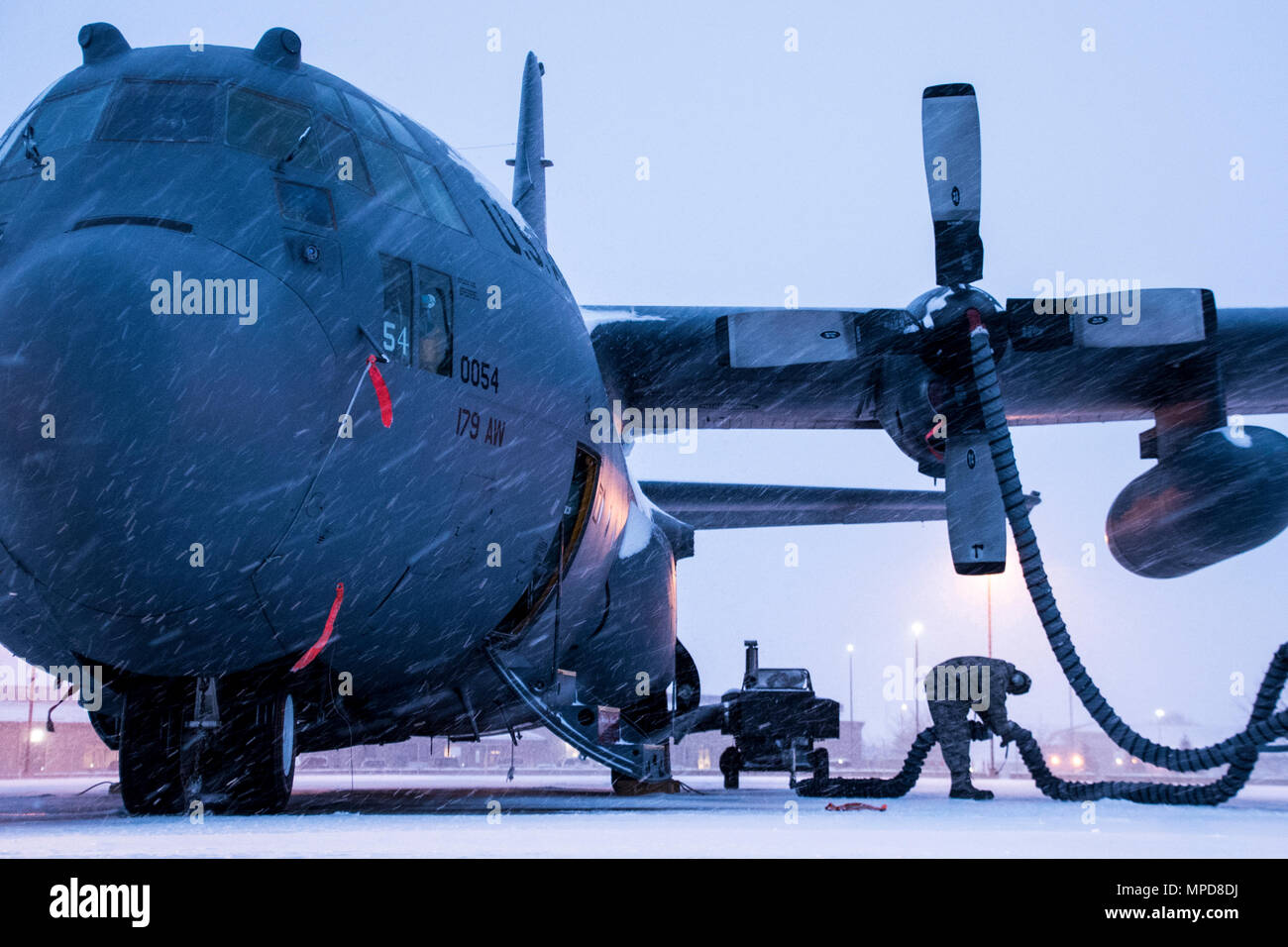 179th Airlift Wing Maintenance members prep the fleet of C-130H Hercules as a blanket of snow decends on them Feb. 9, 2017, at the 179th Airlift Wing, Mansfield, Ohio.  The 179th Airlift Wing is always on mission to be the first choice to respond to community, state and federal missions with a trusted team of highly qualified Airmen. (U.S. Air National Guard photo by 1st Lt. Paul Stennett/Released) Stock Photo