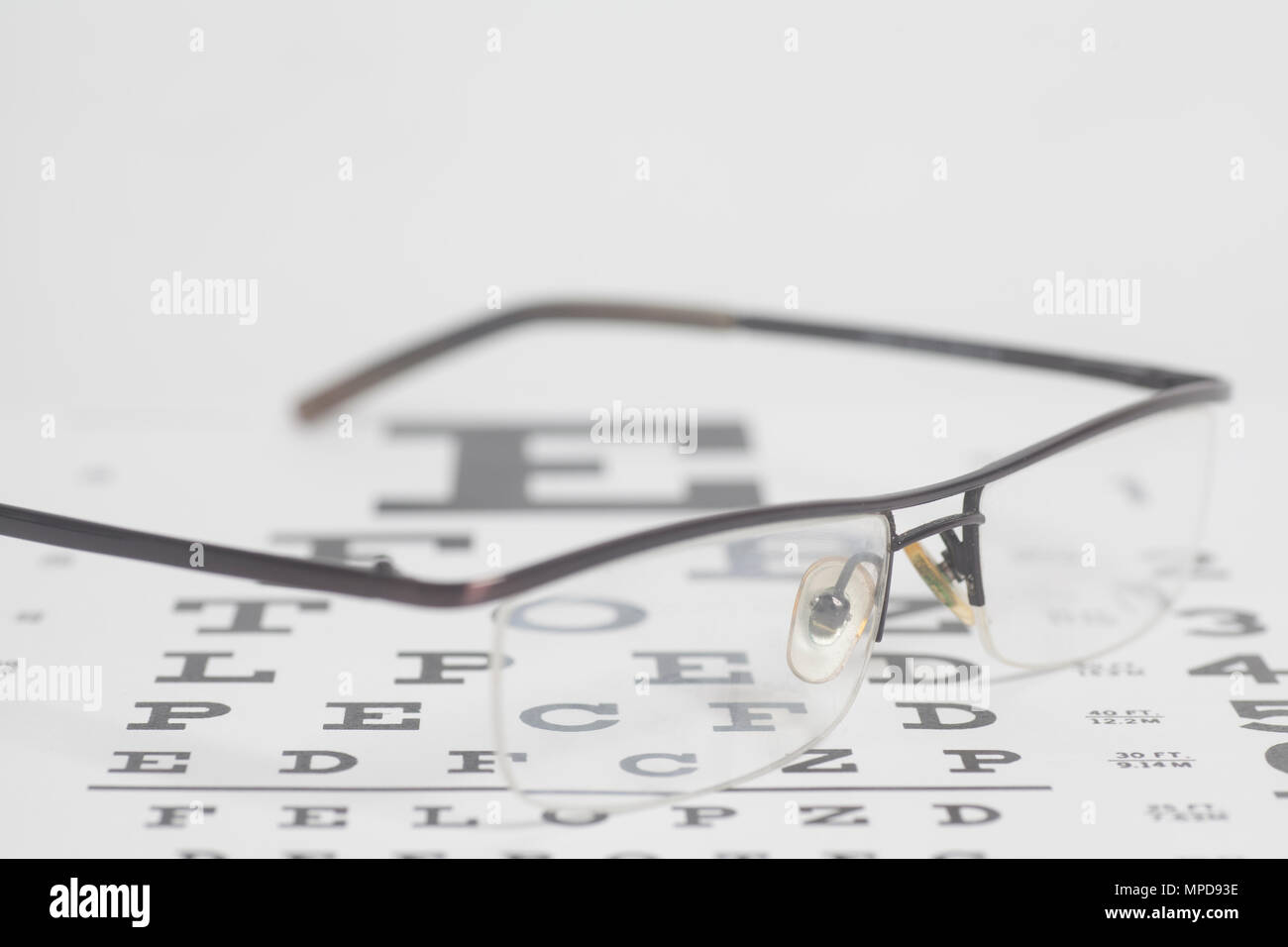 Eyeglasses on eyesight test chart background. Stock Photo