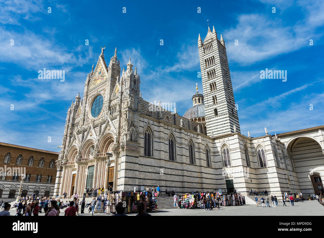 SIENA, ITALY - APRIL 8, 2018: Unidentified people in front of the Siena Cathedral, Italy. It is a medieval Roman Catholic Marian church now dedicated  Stock Photo