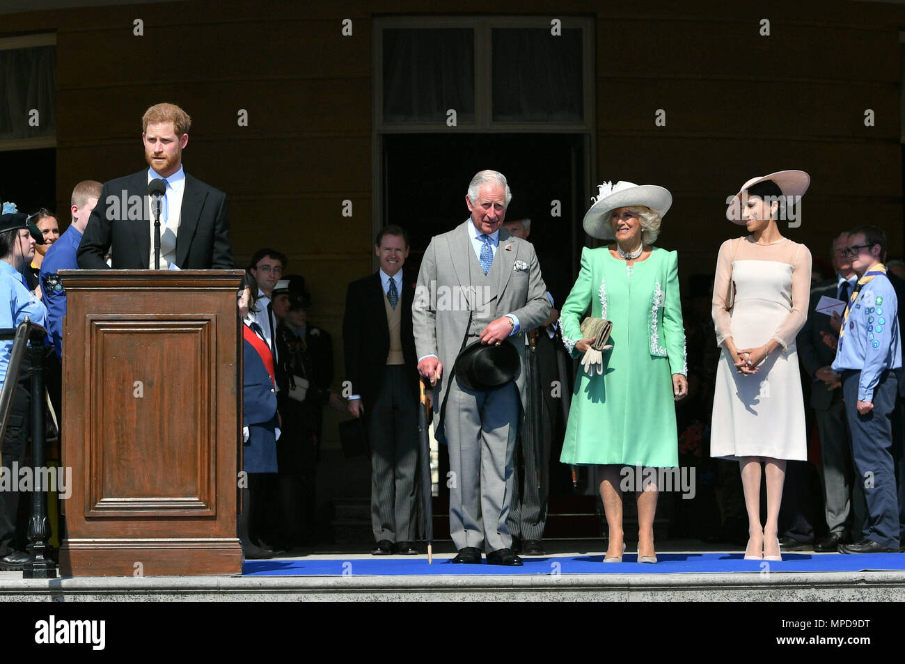 The Prince of Wales, the Duchess of Cornwall and the Duchess of Sussex, listen as the Duke of Sussex speaks during a garden party at Buckingham Palace in London, which the newly weds are attending as their first royal engagement as a married couple. Stock Photo