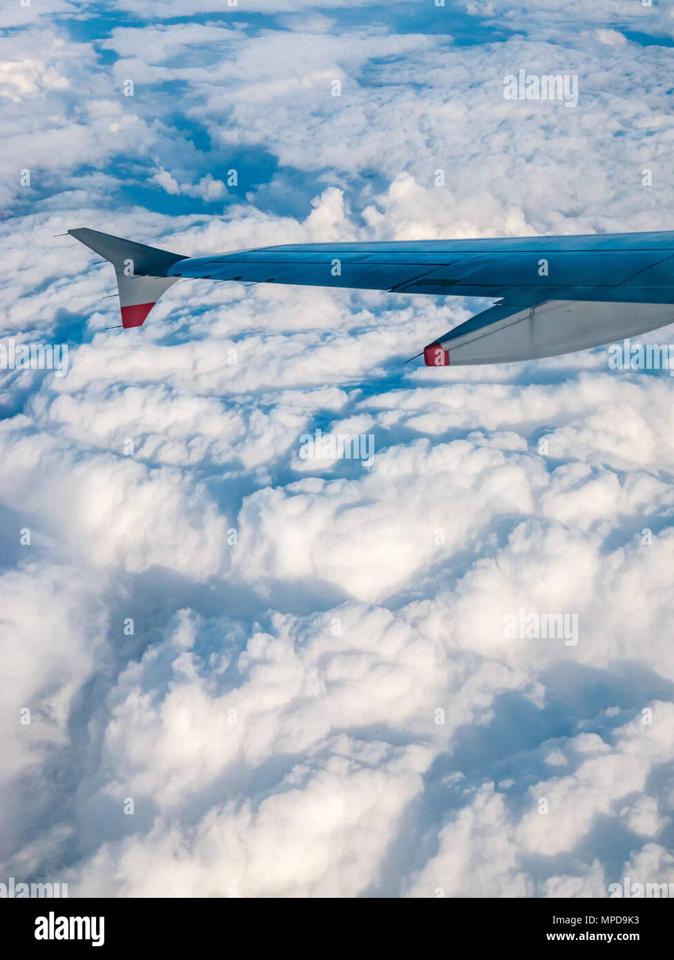British Airways Airbus 319 plane wing seen from plane window during flight above puffy white clouds in United Kingdom Stock Photo