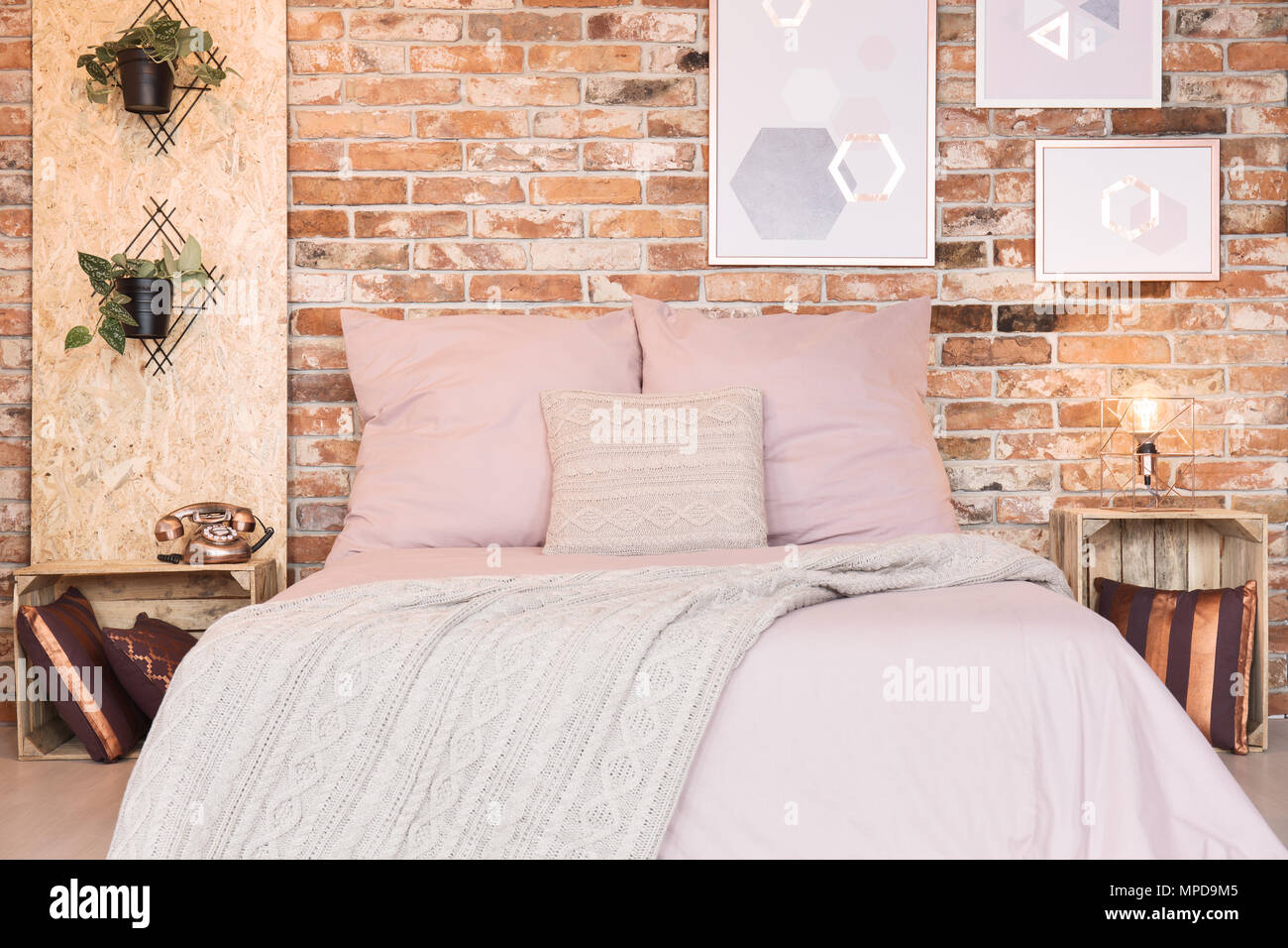 Loft bedroom with double bed and dusty pink bedding Stock Photo