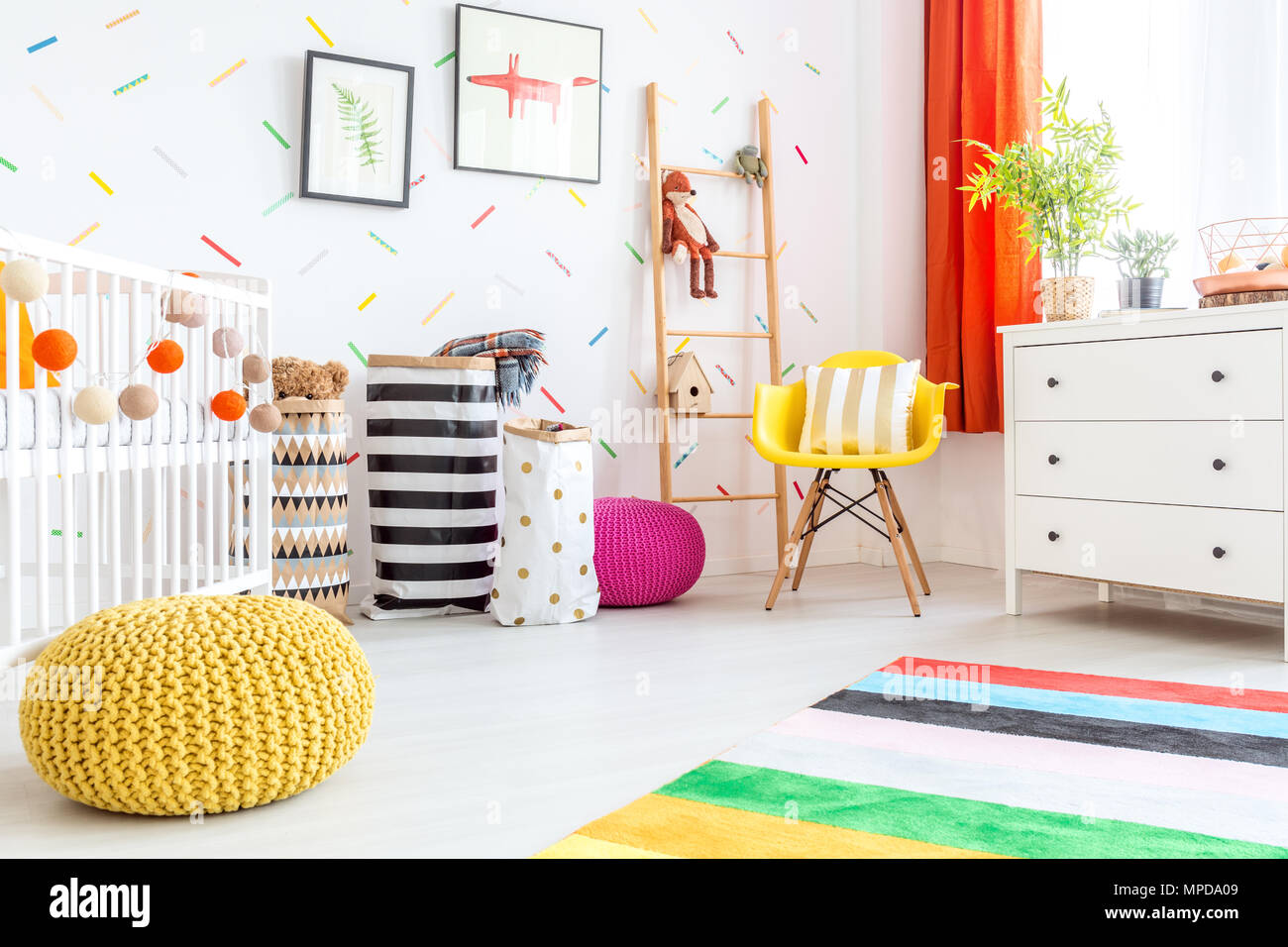 Baby Bedroom With Yellow Pouf And White Dresser Stock Photo