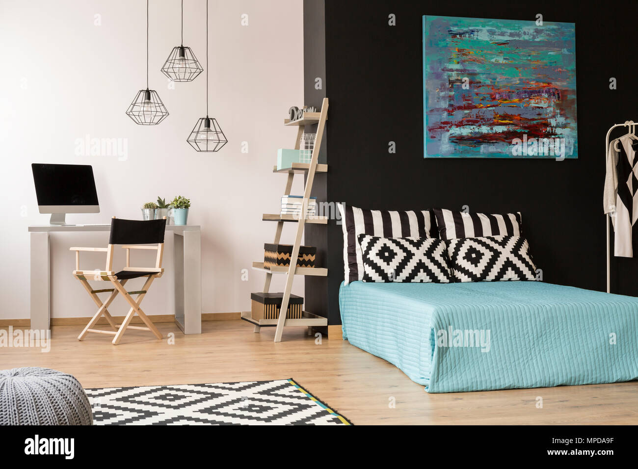 Modern style black and white flat with bed, clothes rack, desk, chair