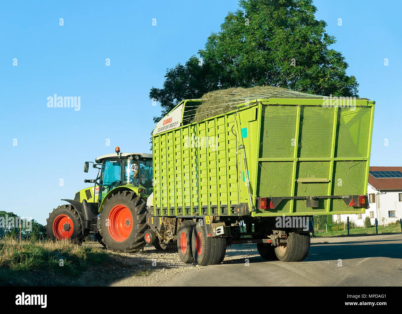 Ouhans, France - August, 25, 2016: Tractor with trailer full of hay on the road in Bourgogne-Franche-Comte region, France. Stock Photo