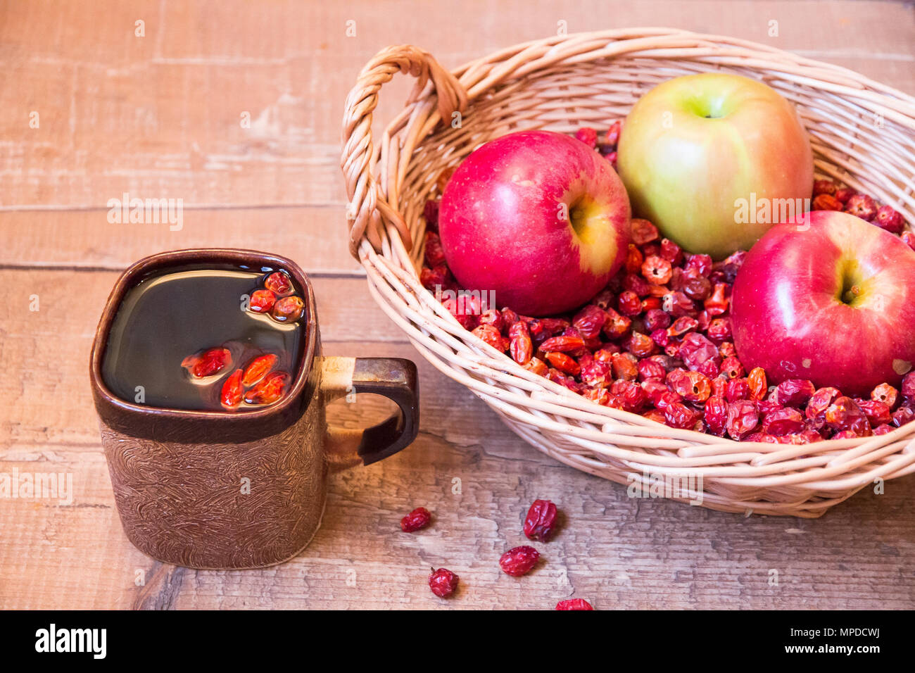 Mug Of Black Tea Rosehip Next To Wicker Basket Filled With Dried Wild Rose And Apples On Wooden Surface Stock Photo Alamy