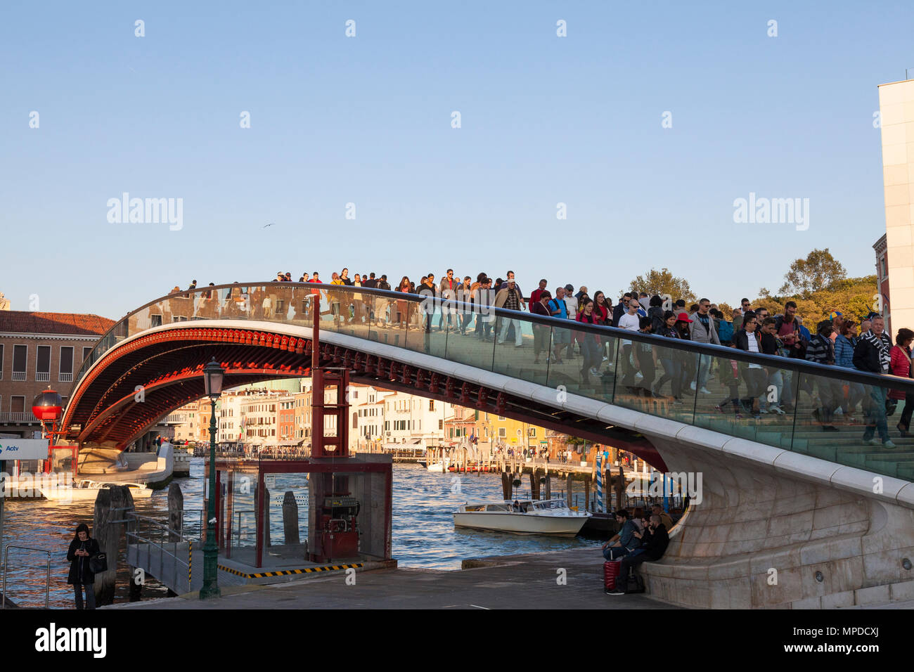 People crossing Calatrava Bridge (Ponte della Costituzione), Grand Canal at sunset, from Santa Lucia Railway Station to Piazzale Roma, Venice, Italy Stock Photo