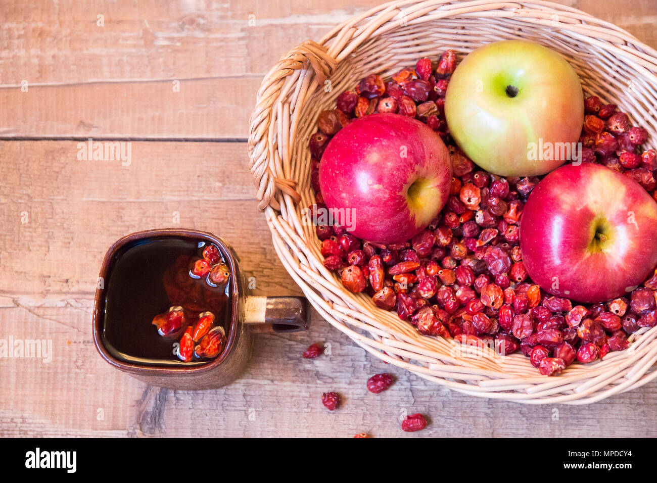 Mug Of Black Tea Rosehip Next To Wicker Basket Filled With Dried Wild Rose And Apples On Wooden Surface Stock Photo Alamy