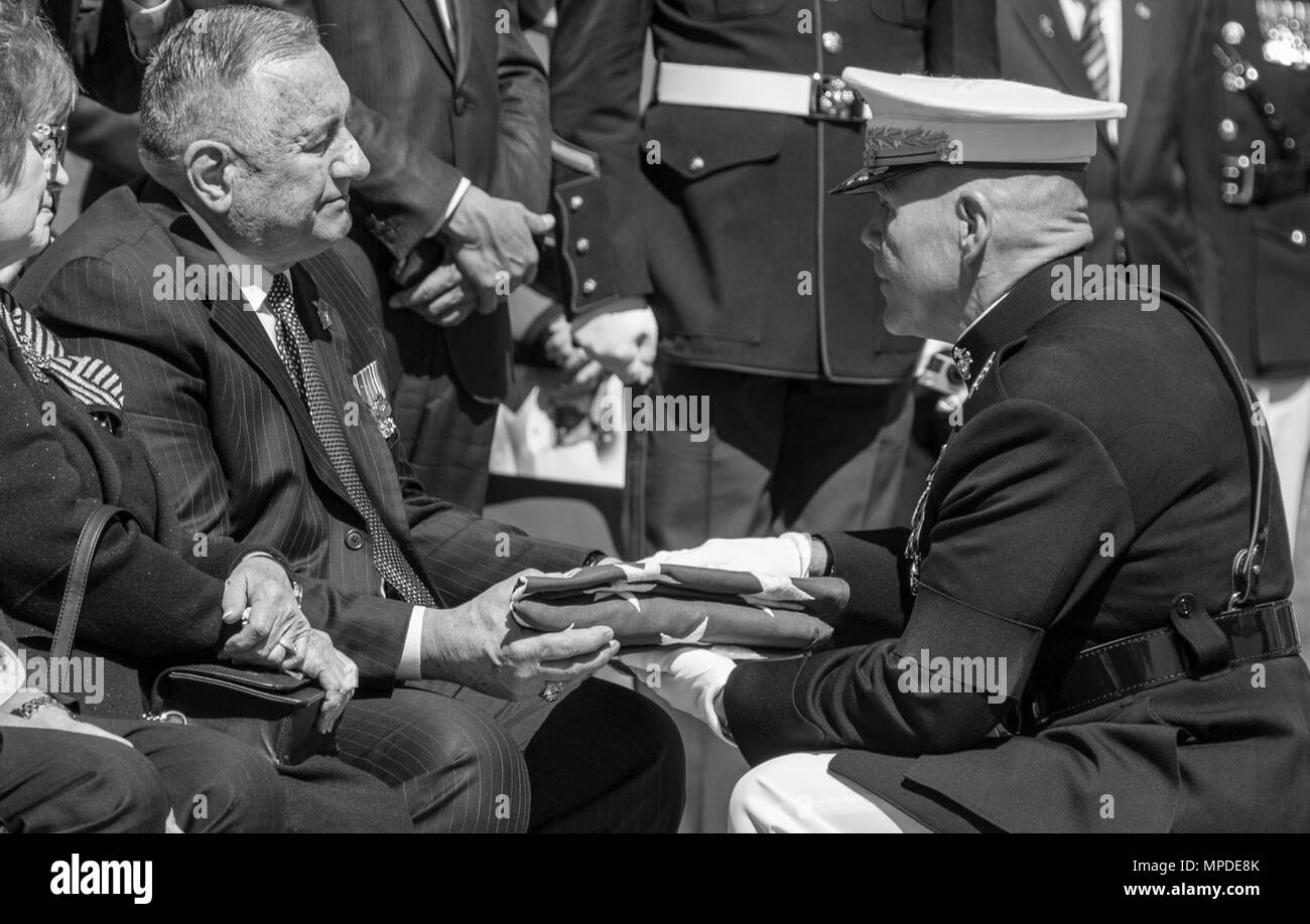 Commandant of the Marine Corps Gen. Robert B. Neller, right, presents a flag to John S. Snowden, son of retired Lt. Gen. Lawrence F. Snowden, during his memorial service at Marine Corps Base Quantico, Va., April 8, 2017. Snowden served in World War II, the Korean War, Vietnam War, and was the senior survivor of the Battle of Iwo Jima. Stock Photo