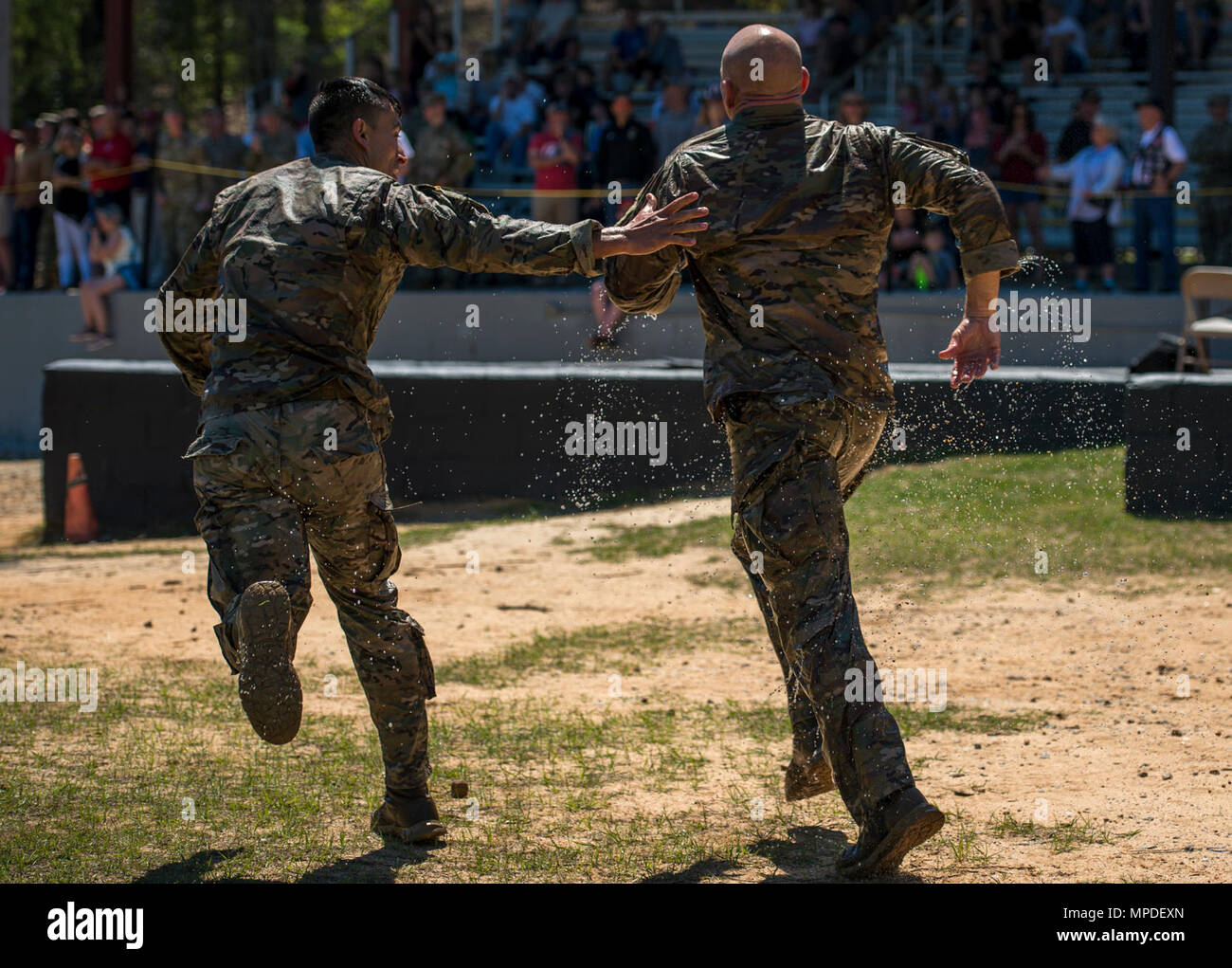 U.S. Army Sgt. 1st Class Joshua Rolfes motivates Staff Sgt. Anthony Allen, both 199th Infantry Brigade Rangers, as they run to the finish line at the Victory Pond event during the Best Ranger Competition 2017 in Fort Benning, Ga., April 9, 2017. The 34th annual David E. Grange Jr. Best Ranger Competition 2017 is a three-day event consisting of challenges to test competitor's physical, mental, and technical capabilities. Stock Photo