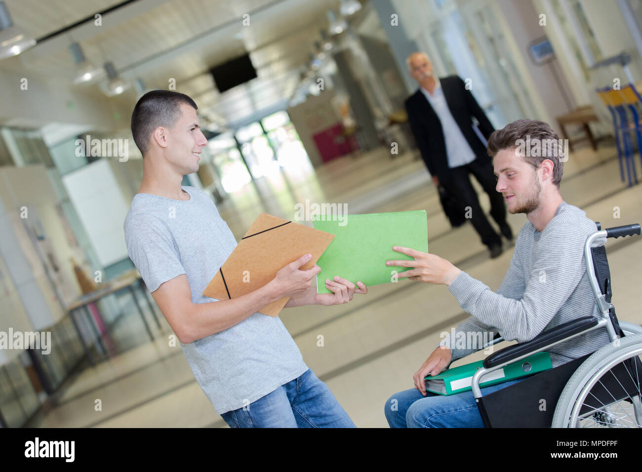 young man in wheelchair with friend Stock Photo - Alamy