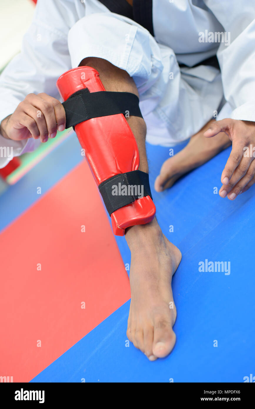 Martial arts fan putting on a leg guard Stock Photo