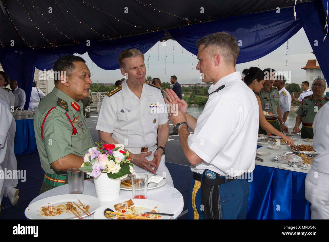 PORT KLANG, Malaysia (April 10, 2017) Malaysian Army Lt. Gen. DATO Fazil Bin Mukhtar, Commander, Joint Forces Command, talks with Vice Adm. Joseph P. Aucoin, Commander, U.S. 7th Fleet, and Lt. Col. Tom Stevenson during the reception for the opening ceremony for Pacific Partnership 2017 Malaysia aboard expeditionary fast transit vessel USNS Fall River (T-EPF 4). Pacific Partnership is the largest annual multilateral humanitarian assistance and disaster relief preparedness mission conducted in the Indo-Asia-Pacific and aims to enhance regional coordination in areas such as medical readiness and  Stock Photo