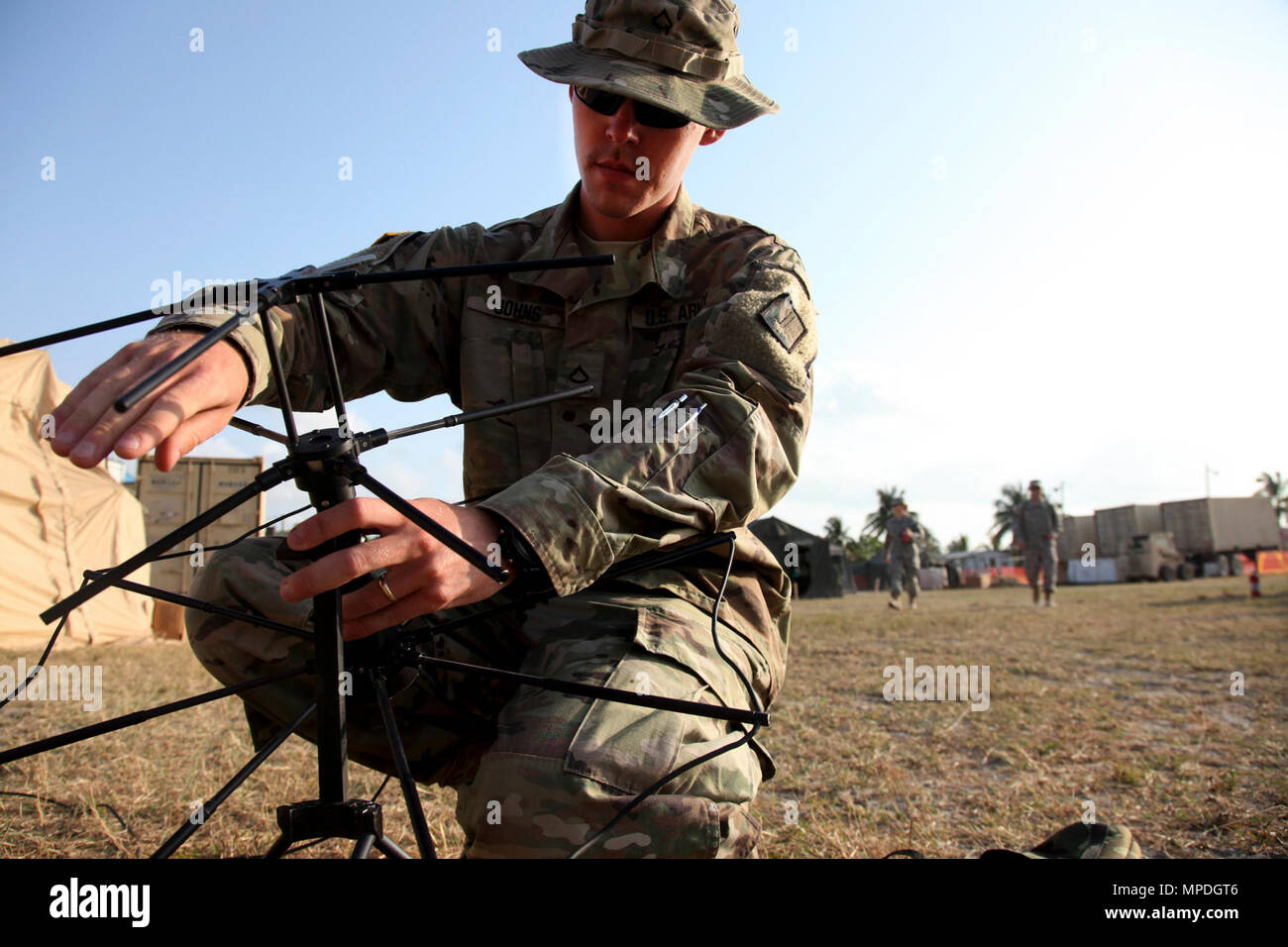 U.S. Army Pfc. Christopher Johns of the 56th Signal Battalion, sets up communications with his local command group in support of operation Beyond the Horizon, in Belize City, Belize, April 9, 2017. Beyond the Horizon is a partnership exercise between the U.S. military, Belize Defense Force and multiple Belize government agencies that will consist of five construction projects and three medical service events in the districts of Belize, Cayo and Stann Creek. Stock Photo