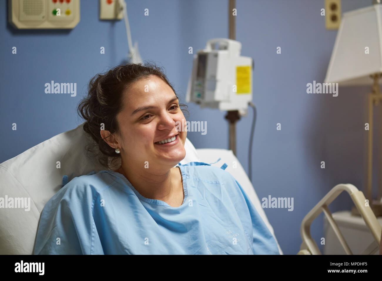 Happy smiling patient in hospital. Young hispanic woman patient Stock Photo