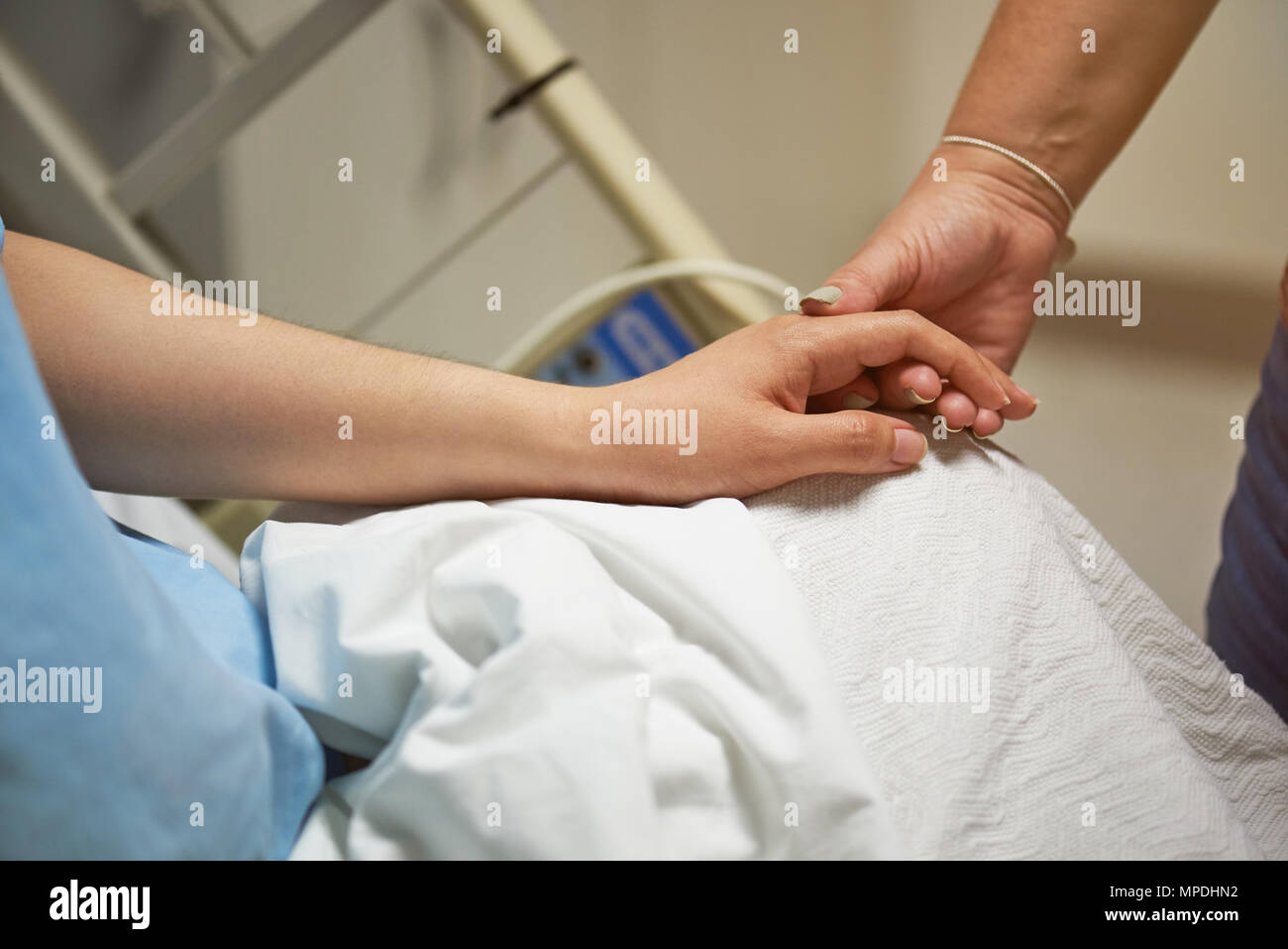 Medical support theme. Close up of patient hand holding relative hand Stock Photo