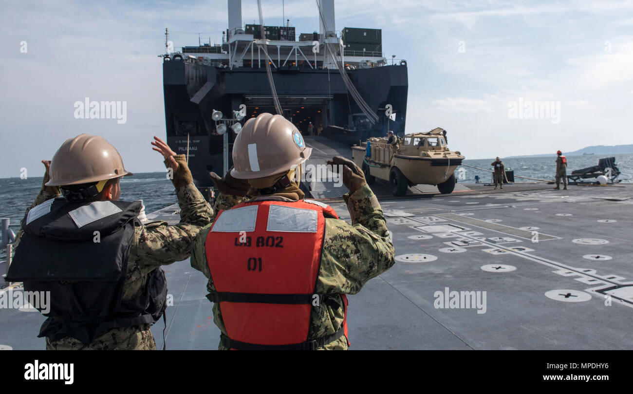 POHANG, Republic of Korea (Apr. 10, 2017) Seaman Lillie Guzman (left) and Boatswain’s Mate Seaman Brittany Summerour (right) direct the offloading of equipment from Navy Maritime Prepositioning Force Ship USNS Pililaau (T-AK 304), utilizing a roll-on, roll-off discharge facility (RRDF) while anchored off the coast of Pohang, Republic of Korea during Combined Joint Logistics Over the Shore (CJLOTS) April 10. CJLOTS is a biennial exercise conducted by military and civilian personnel from the United States and the Republic of Korea, training to deliver and redeploy military cargo as a part of exe Stock Photo