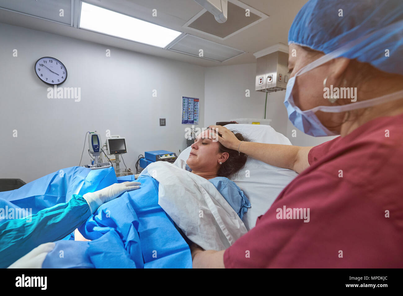 Nurse helping in baby delivery in clean hospital room Stock Photo