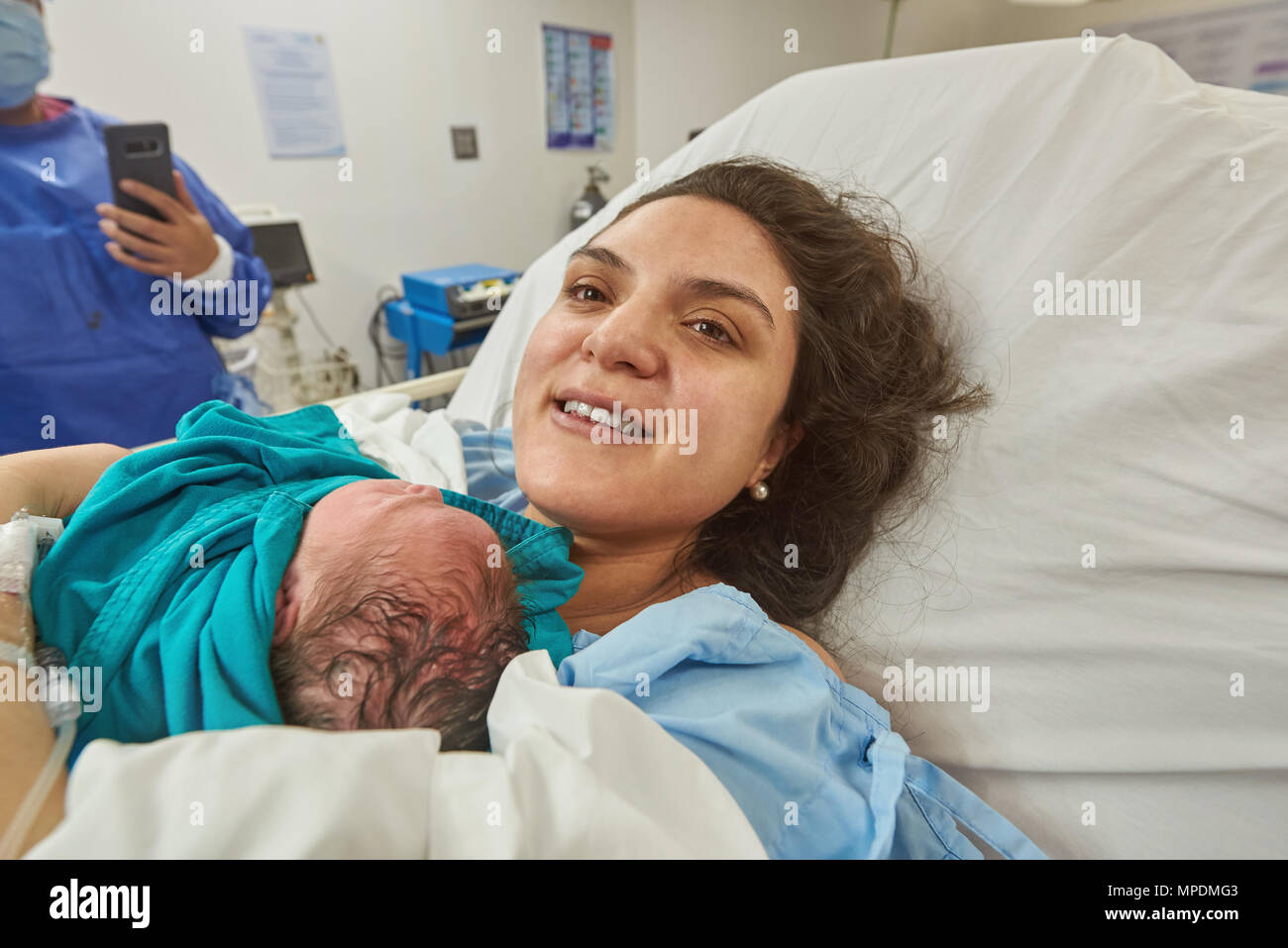 Happy mother with newborn in hospital room background Stock Photo