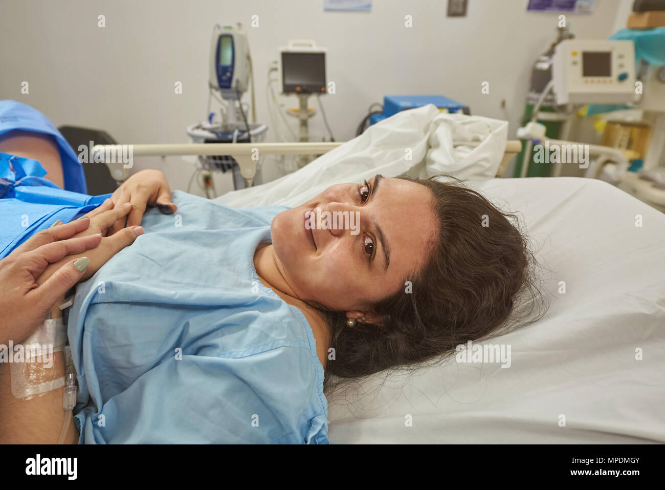 Smiling hispanic woman in hospital bed after surgery Stock Photo Alamy