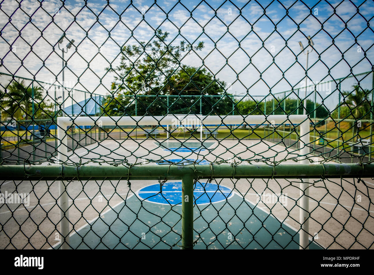 basketball court and soccer field in public park behind fence Stock Photo