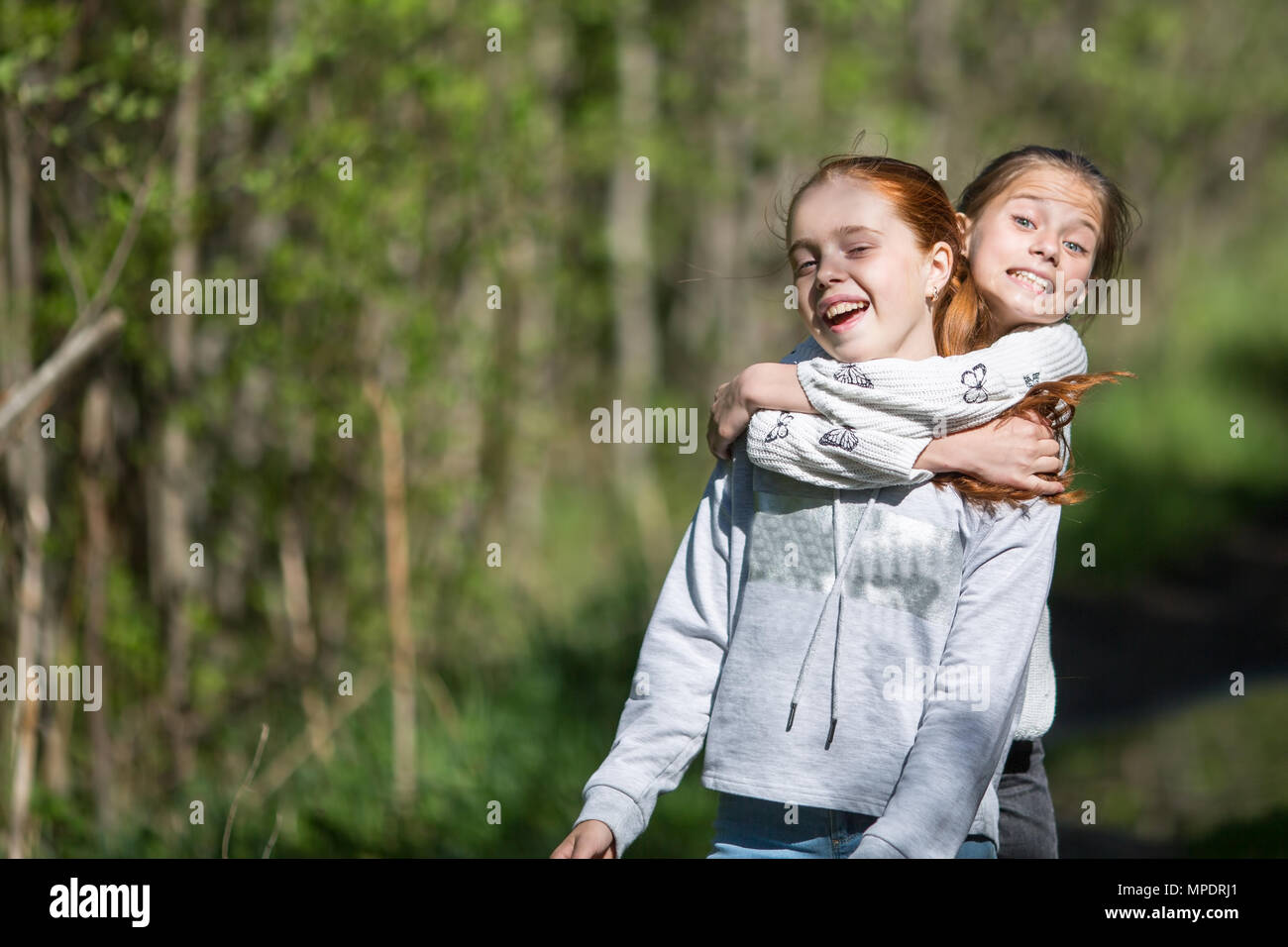 Two sisters  teen girls friends hugs and having fun in the Park at summer. Stock Photo