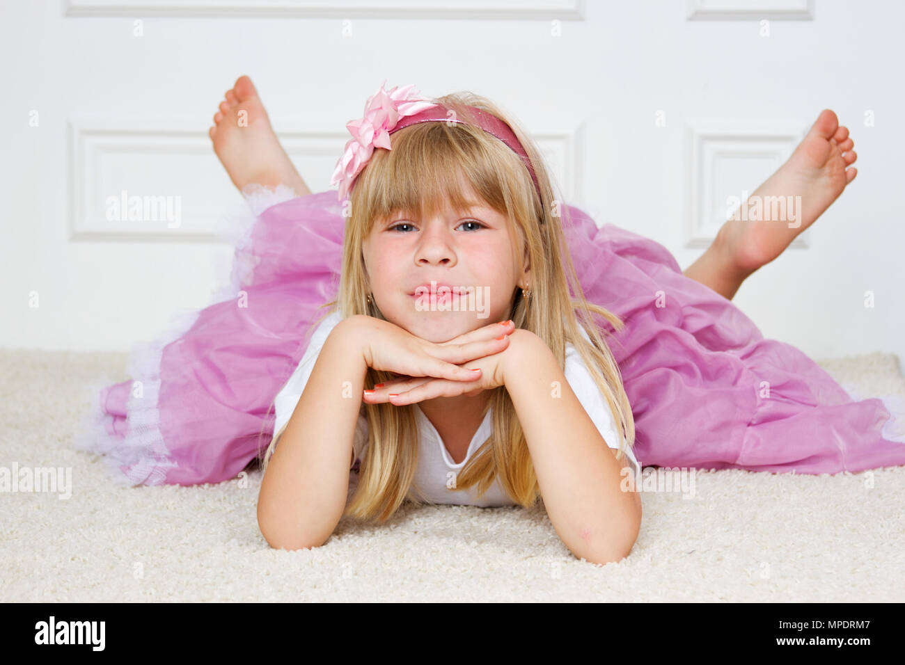 Beautiful girl lying on floor studio shot Stock Photo - Alamy
