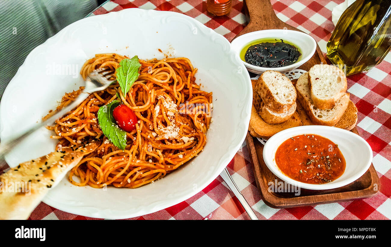 Spaghetti napolitan or bolognese served with tomato and olive paste