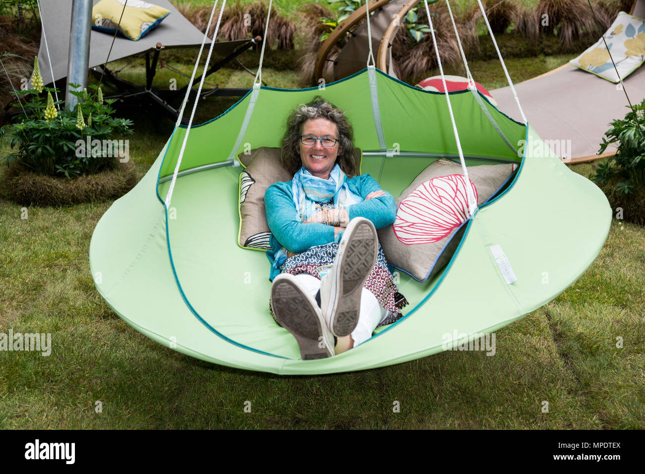 A visitor relaxes in a hanging chair by HangInOut at the RHS Chelsea