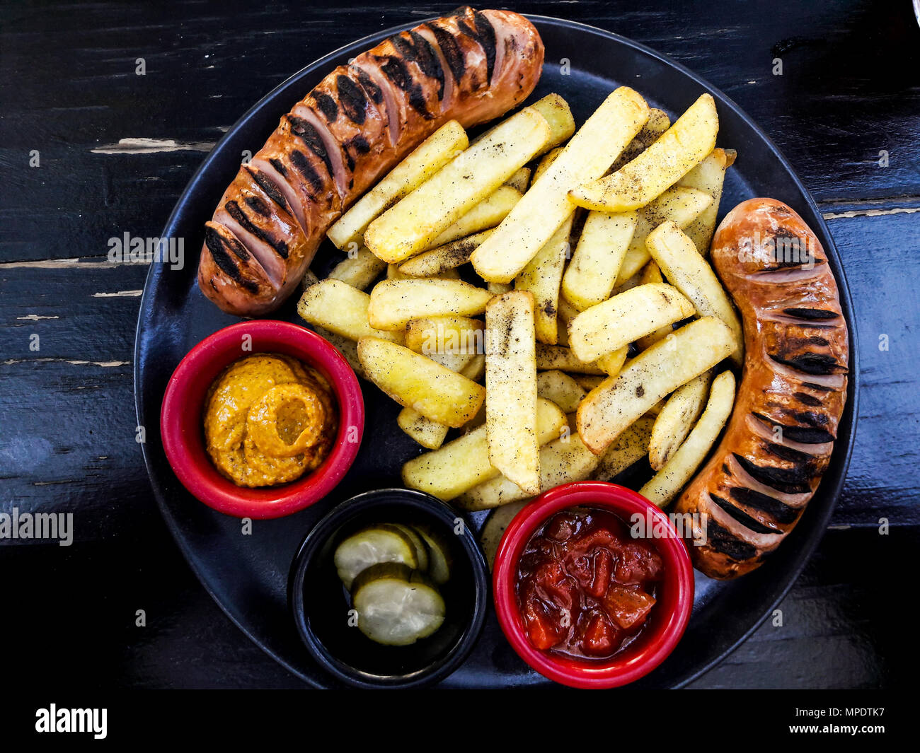 Frankfurter Sausage with potatoes, salsa sauce and mustard. fast food concept. Stock Photo