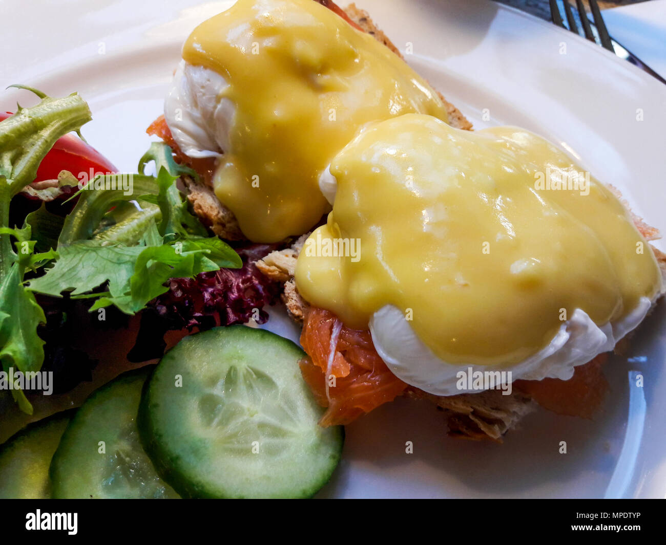 Egg Benedicts with Salmon served with cucumber and salad. Organic Food